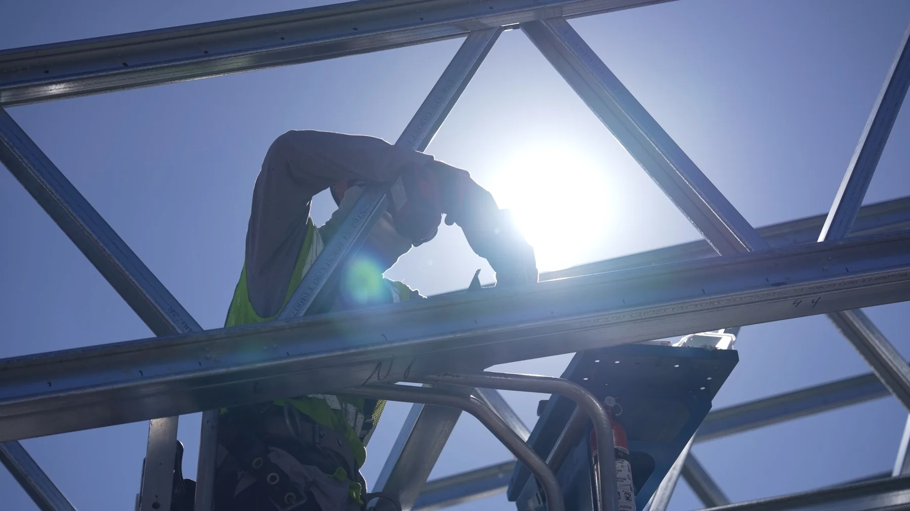 Worker framed by steel and sunlight